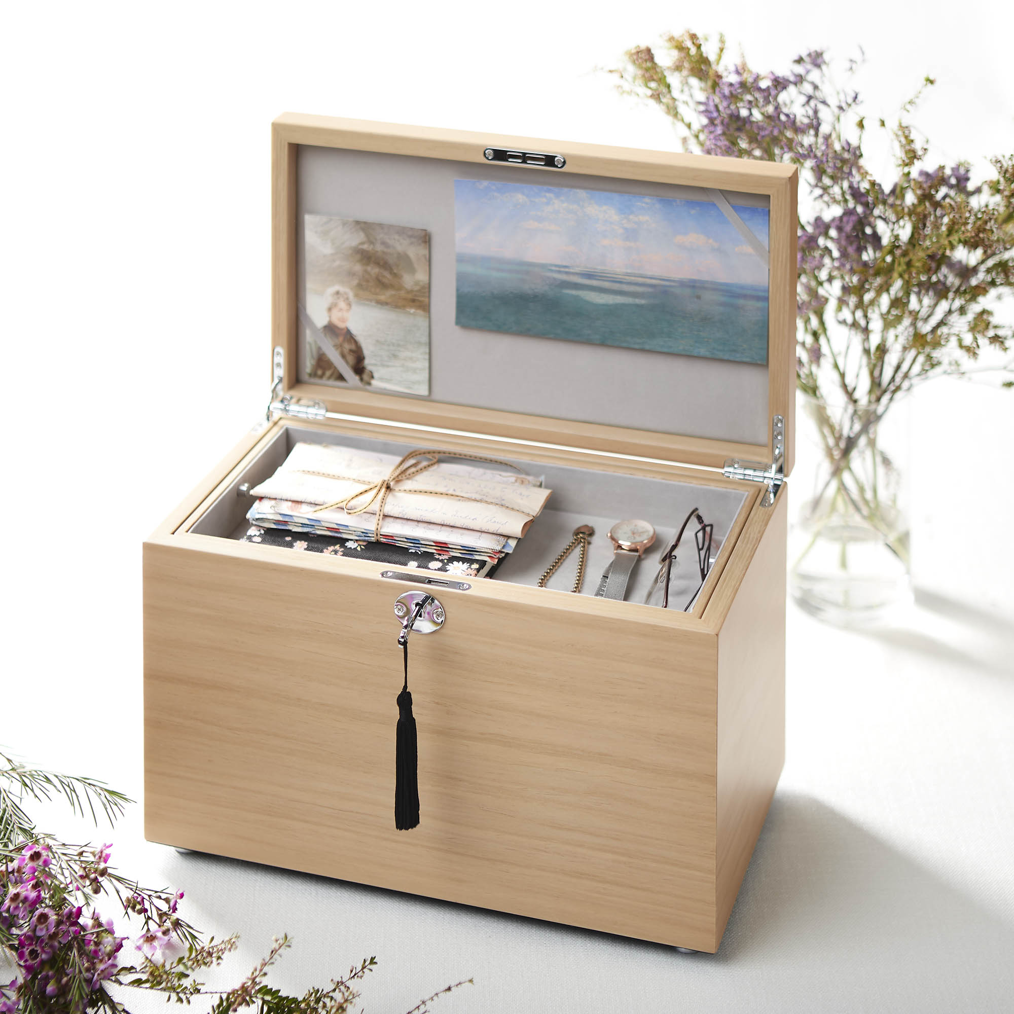Wooden jewelry box with jewelry and a scenic image on a white background
