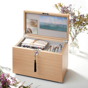 Wooden jewelry box with jewelry and a scenic image on a white background