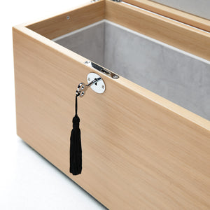 Wooden box with a black tassel hanging from a hook on a white background