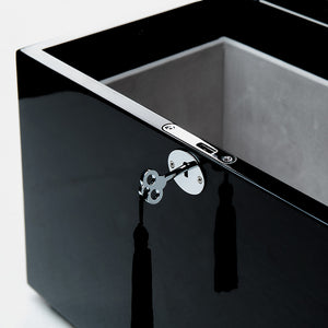 Close-up of a black metal sink with a key attached to it on a white background