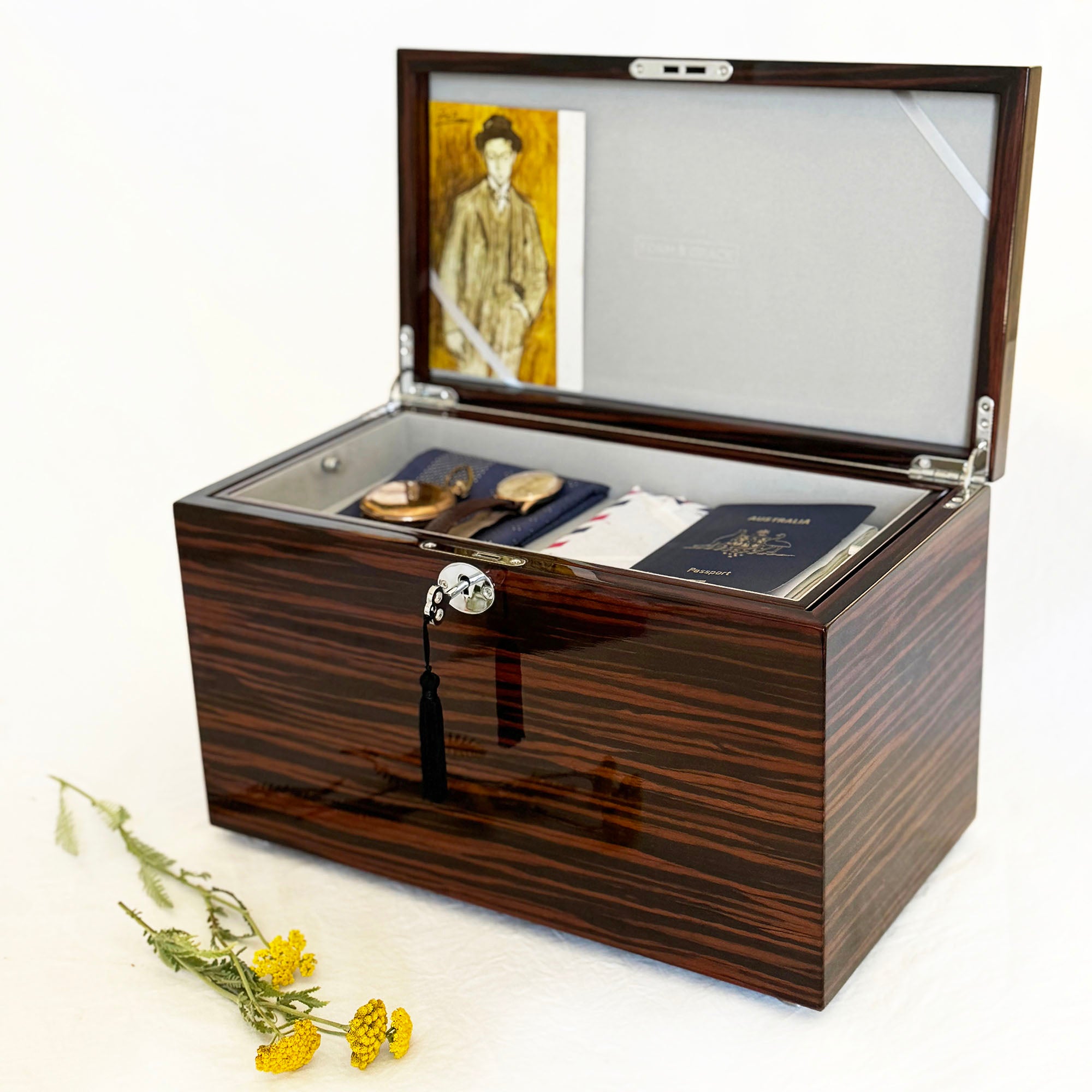 Wooden urn with an open lid displaying jewelry items on a white background.